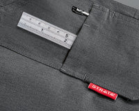 A grey pocket of a PPE trouser is shown in which a ruler and pen sits. A red Strata label is on the lapel. To support information about ASTM F1506