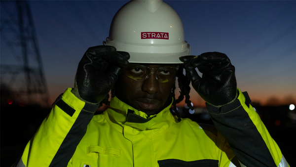 A man in front of a sunset adjusts his helmet and visor to support our guide on EN 166 Personal Eye Protection